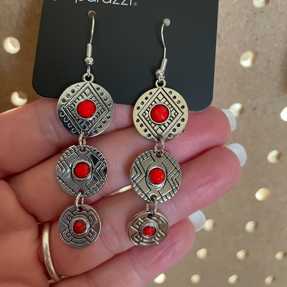 Silver Aztec discs with red stone centers.